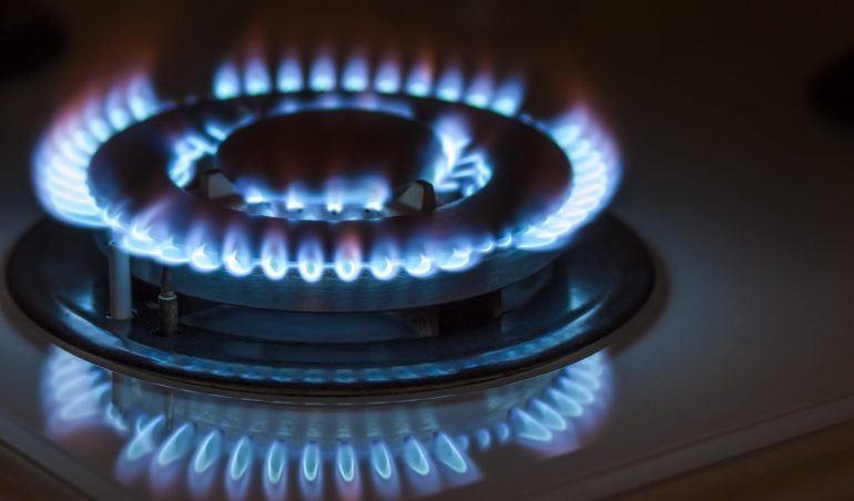 Closeup shot of blue fire from domestic kitchen stove. Gas cooker with burning flames propane gas.